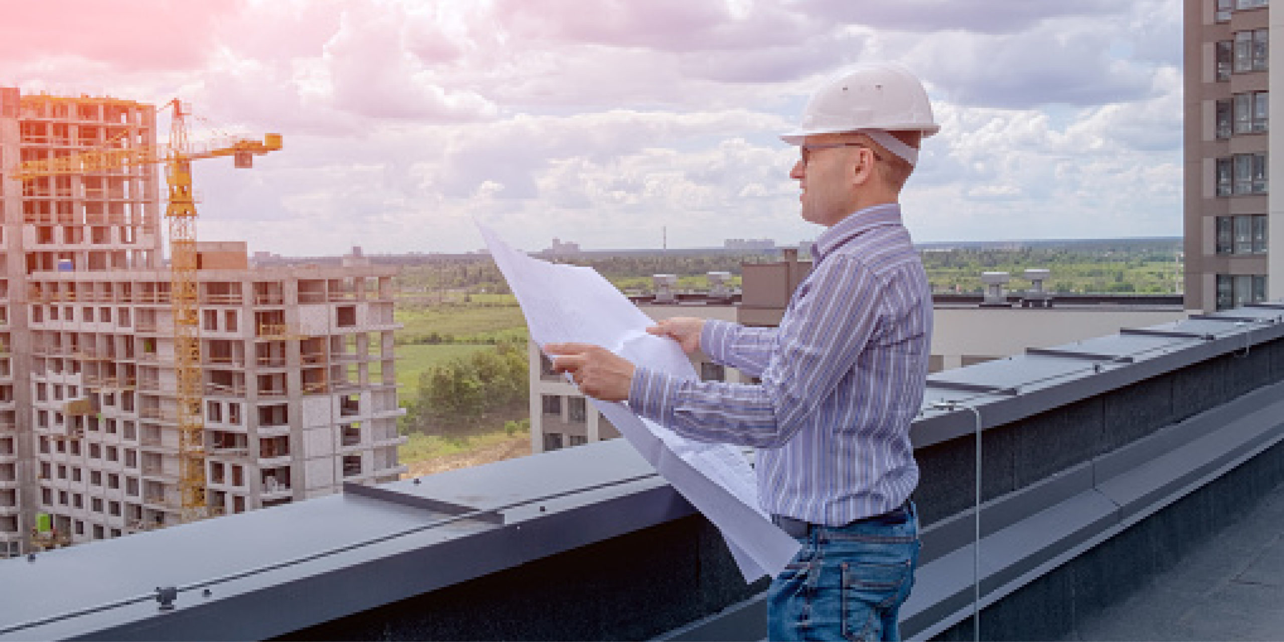 homme regardant le plan d'un bâtiment sur un chantier