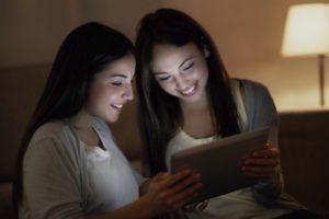 two women watching a movie on an ipad