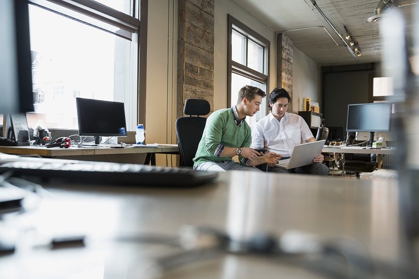 two professionals reviewing digital automation functions such as room controllers