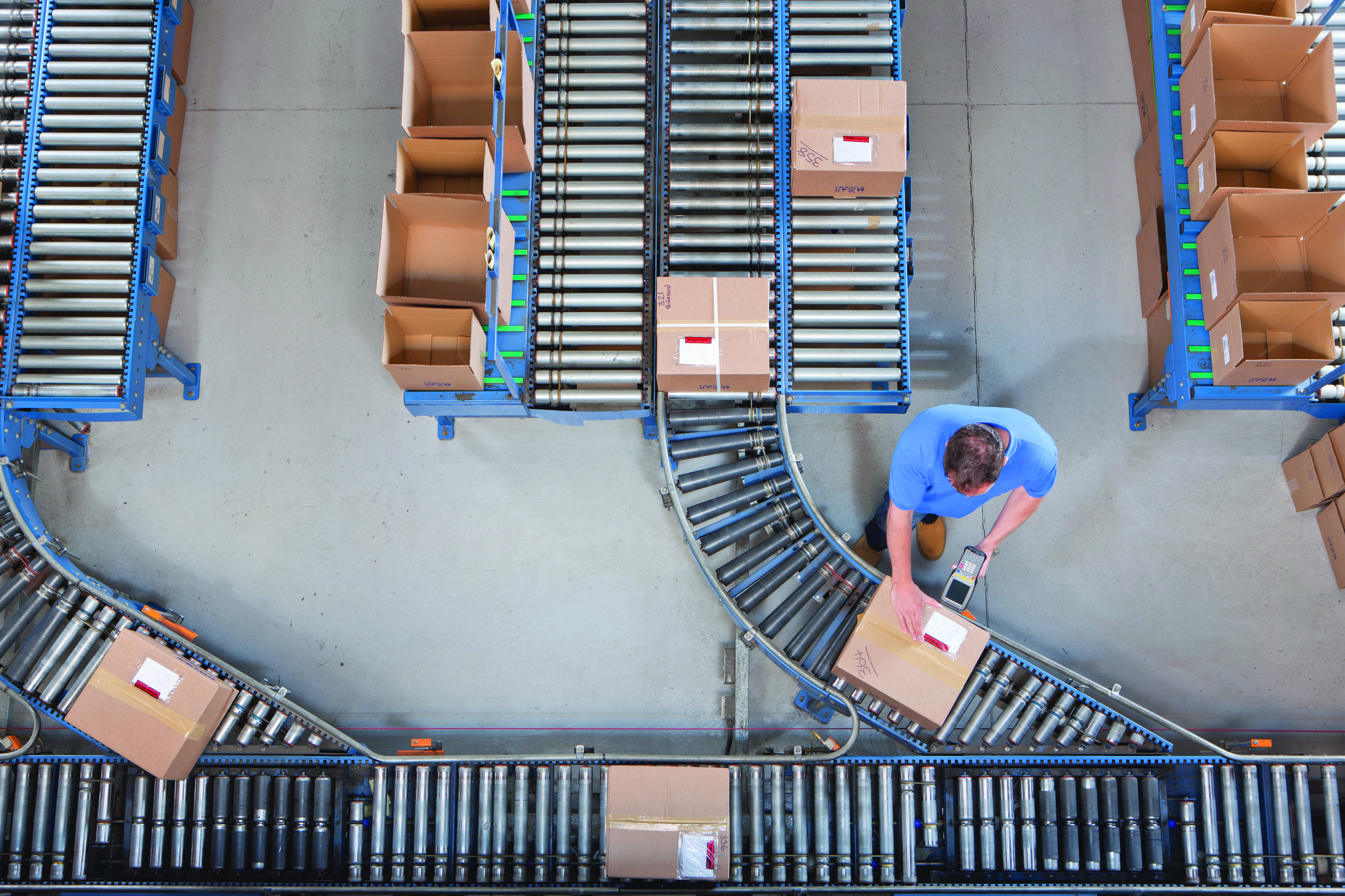 A man scanning a box moving on a conveying belt