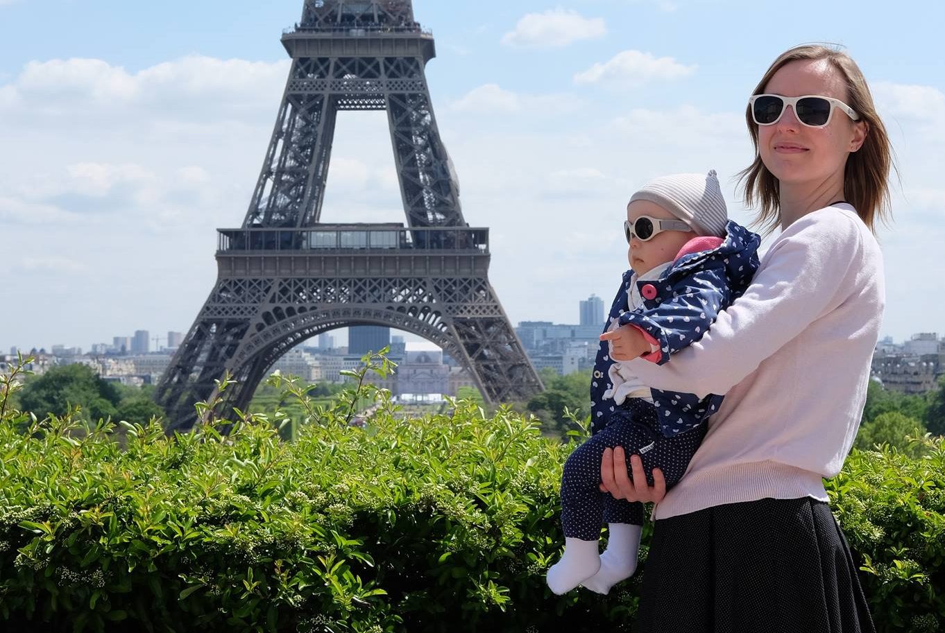 Holding a baby near Eiffel Tower