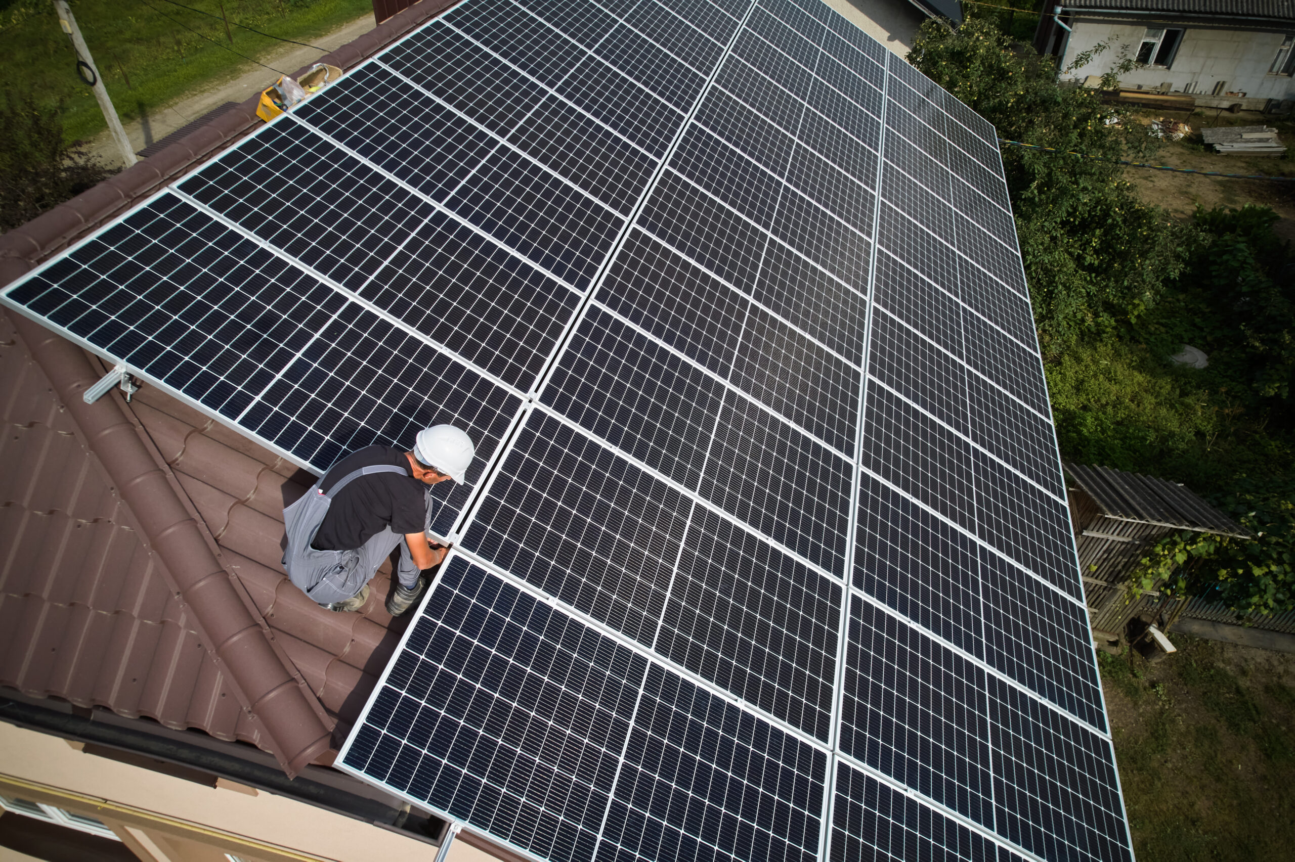 a solar panel installer on the roof of a building setting up solar panels