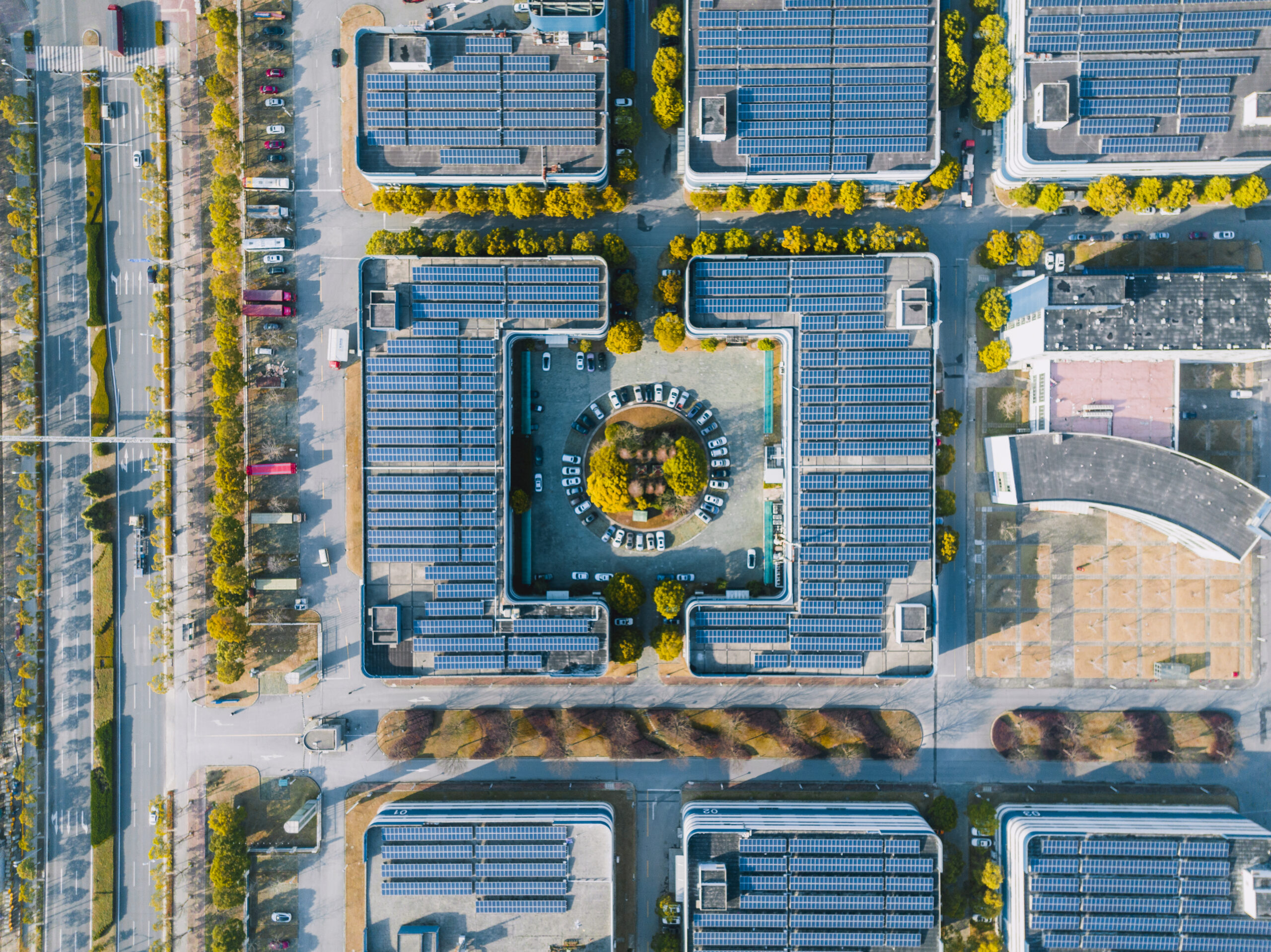 An aerial view of a cluster of buildings with solar panel arrays on the roofs.