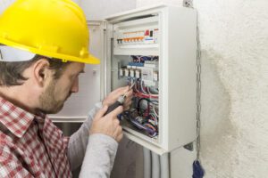 An electrician at work on an electrical panel