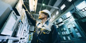 An operator inspects switches in a power plant