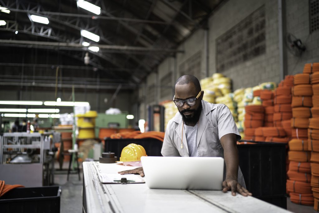 Engineer working at the factory using laptop