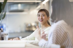 Two women sitting at a desk having a discussion