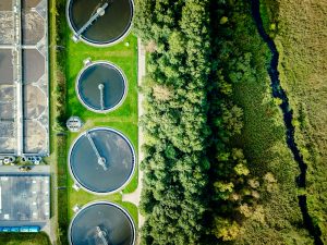 Aerial shot of sewage treatment plant placed near a river, Denmark. Aerial view shot with drone.