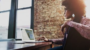 the-image-portrays-a-professional-looking-at-their-laptop-while-in-the-office