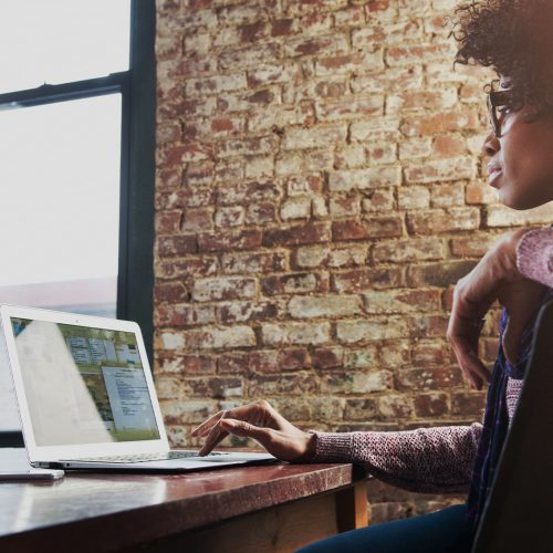 the-image-portrays-a-professional-looking-at-their-laptop-while-in-the-office