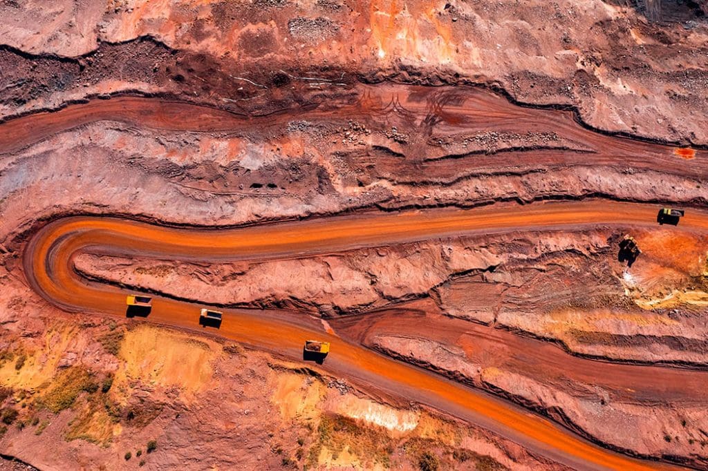 Aerial view of open pit iron ore and heavy mining equipment.