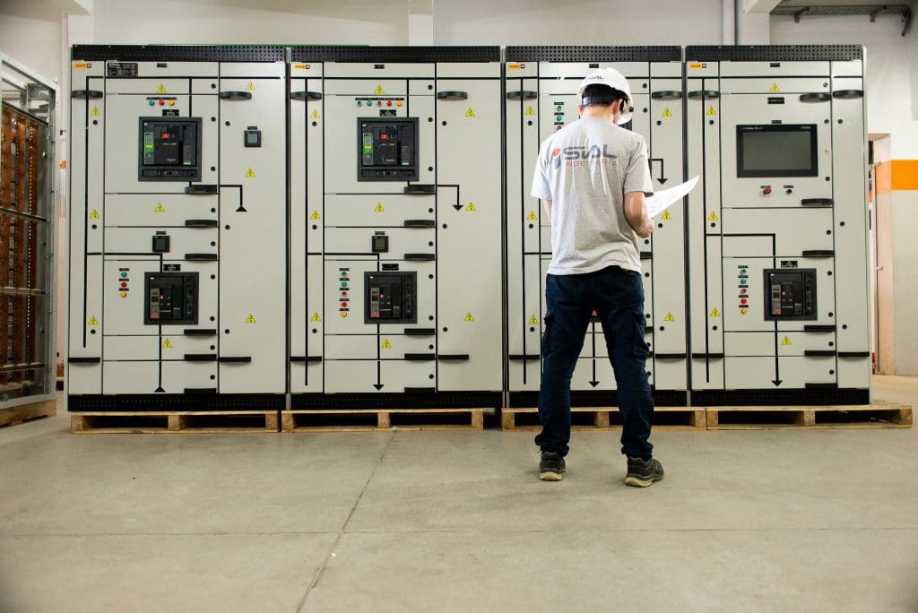 A SIAL engineer stands in front of a modular low-voltage system, with their back to the camera.