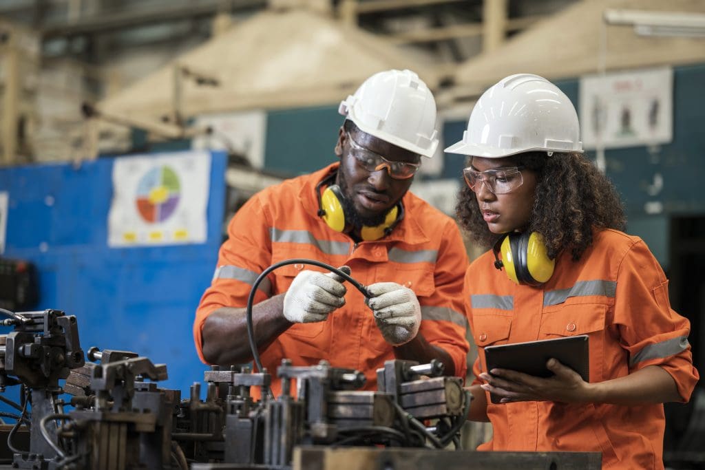 Alignment and assembly jigs developed to boost quality and efficiency in an auto parts manufacturing Industry. Two African American Process Engineers discussions on assembly jig and verify the dimensional accuracy of the fixture to increase durability for support in a production process of condition-based maintenance.