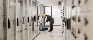 Field service engineer inspect relay protection system with laptop computer. Bay control unit. Medium voltage switchgear