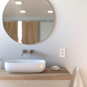 Modern bathroom with basin sink, round mirror and power receptacle