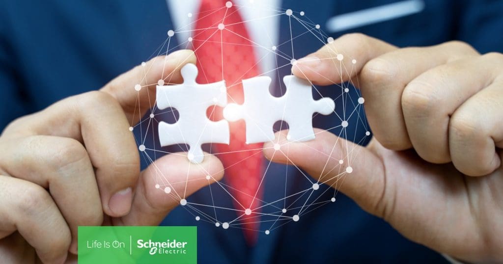 man holding two puzzle pieces coming together to depict IT infrastructure partnership