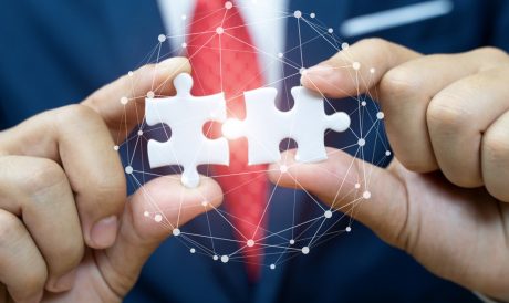man holding two puzzle pieces coming together to depict IT infrastructure partnership