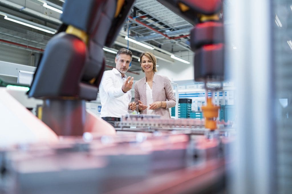 Two professionals discussing automation technology in a modern factory, symbolizing Europe’s industrial productivity paradox and innovation potential.