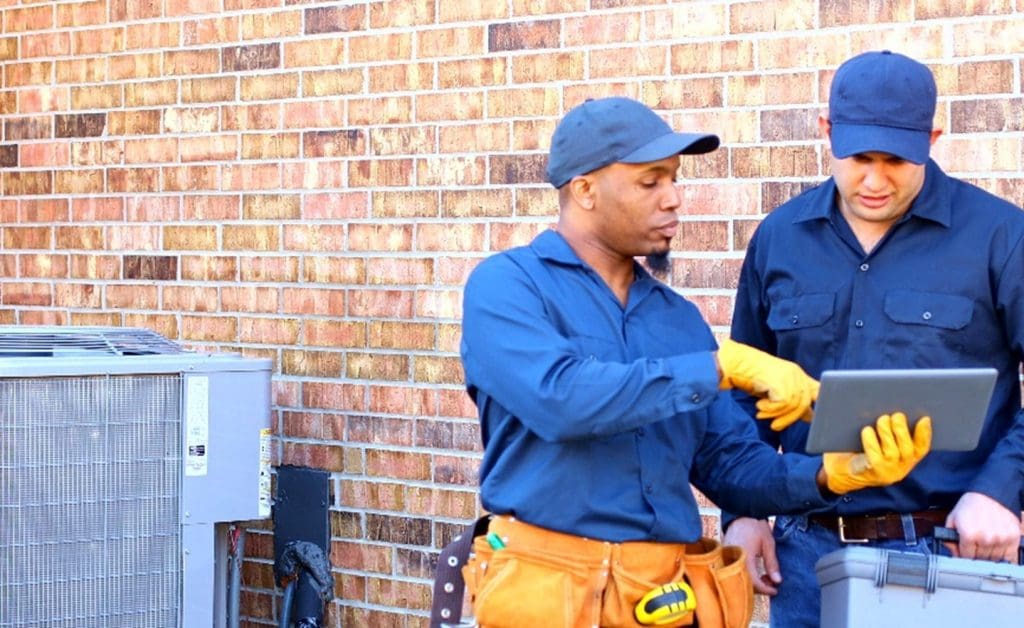 Two electricians looking at a tablet.