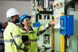 Experienced worker onboards new employee about using predictive control.